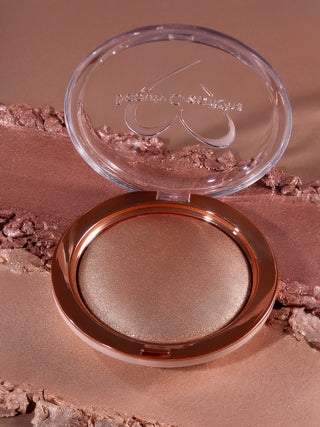 Open compact powder case with brown shade on a brown background. Shade is Bronze Affair Shimmer Veil Beauty Creations Face and Body Highlighter