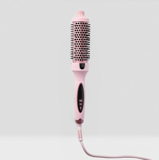 Pink hairbrush with bristle head on a light gray background