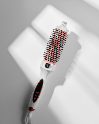 Hairbrush with bristle and ceramic heating elements on a light gray background