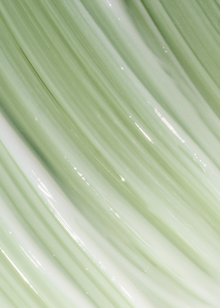A close-up texture shot of glossy, pale mint green fiber optic strands or cables arranged diagonally.